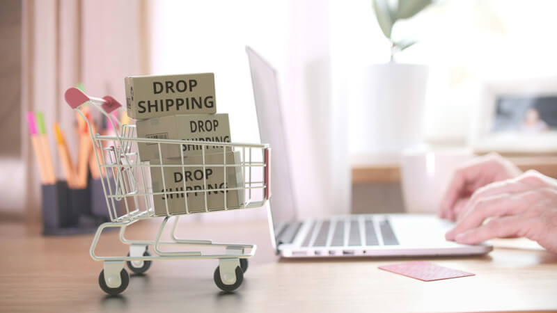 Cartons with dropshipping text on a shopping cart